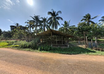 An ultrawide angle shot of old wooden chicken coop on the side of the road at the village in the morning. Selective focus.