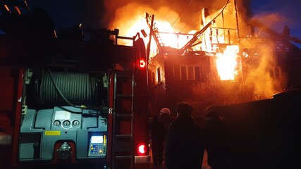The roof of the house is on fire. The residential building burn, village. Firefighters put out a...