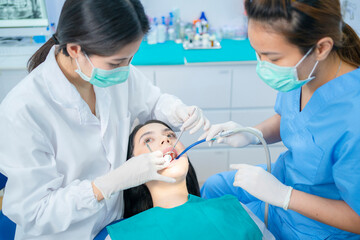 Asian dental team providing oral treatment service in dental clinic.