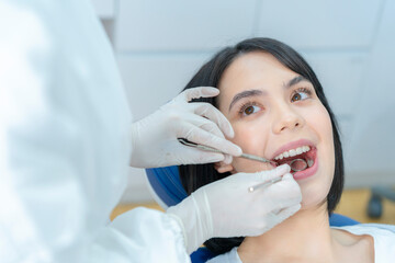 Close-up shot of female patient getting tooth checkup in dental clinic