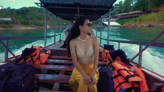 Cute Smiling Asian Sitting on a Long-Tail Boat in Cheow Lan Lake, Thailand.
