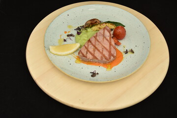 Fresh steak with avocado, lemon, mushroom on white plate