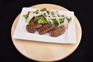 Grilling steaks  with salad and  Parmesan cheese