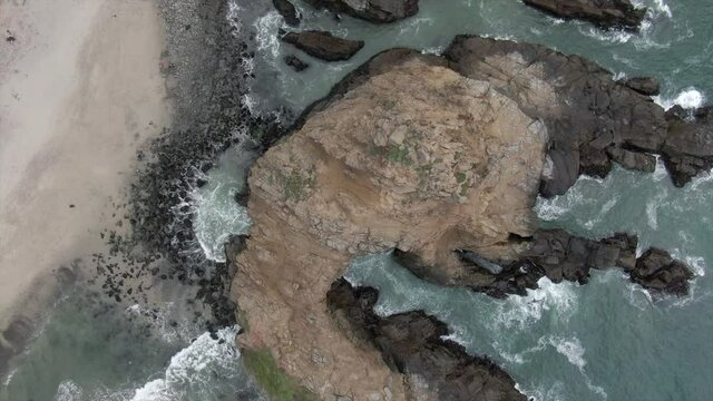 Aerial Top View Of People By Keyhole Arch At Pfeiffer Beach, Drone Ascending Over Famous Natural Landmark Splashing Waves - Big Sur, California