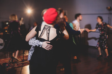 Young couple dance retro jazz swing dances on a ballroom club wooden floor in retro vintage clothes dress, female and male, rock dance lessons, process of dancing