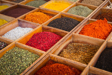 Close-up of beautiful rows of fresh spices: turmeric, cumin, red and black pepper,parsley, peppers,...