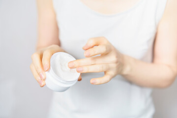 クリームを手に取る中年女性