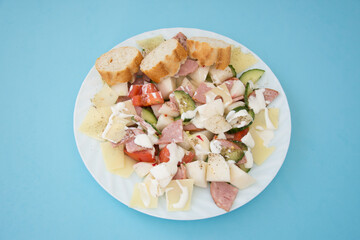 salad with radishes, cheese, tomato pepper cream, cucumber and salami 