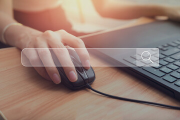Search bar of internet browser and woman working on modern laptop at table.