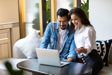 Happy young family couple shopping online with laptop computer. making purchases online concept.