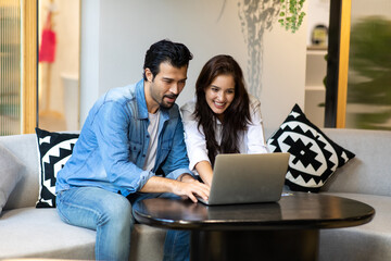Happy young family couple shopping online with laptop computer. making purchases online concept.