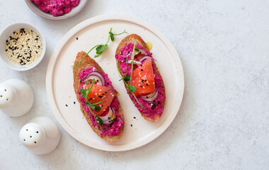 Open face sandwiches with beetroot hummus, salmon, sesame seeds and micro  greens