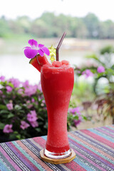 a watermelon smoothie is on the table in the garden.