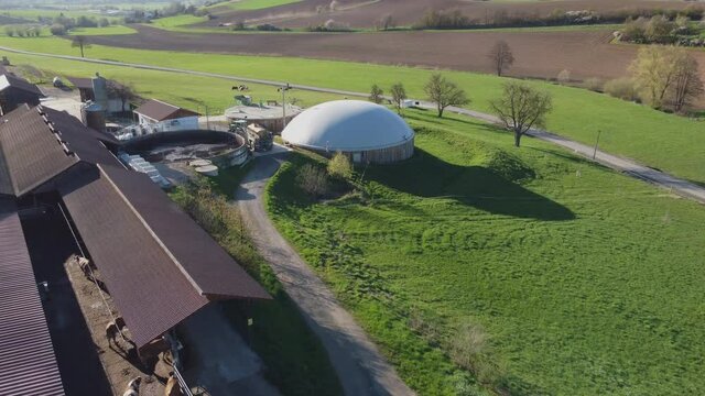 Flight over a farm with biogas plant and animals.