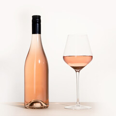 Young woman holding glass of rose wine on white background. Hand with black polish.