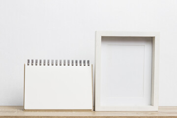 A white photo frame with a white note on table.