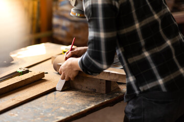 Carpenter woking at wood workshop. Construction industry concept. Tools for woodwrok pencil hammer meter and screw-driver.
