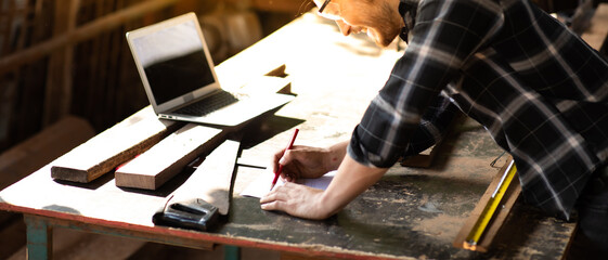 Carpenter woking at wood workshop. Construction industry concept. Tools for woodwrok pencil hammer meter and screw-driver.