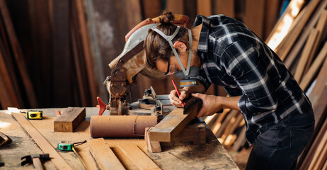 Carpenter work with electrical planer in carpentry workshop. Construction industry concept.