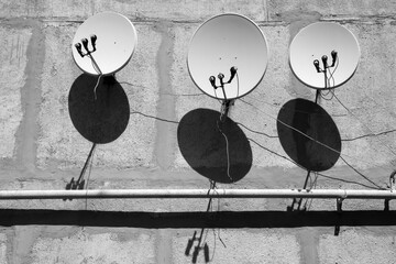 Satellite dishes on the wall of the house. A gas pipe runs below. An original play of light and...