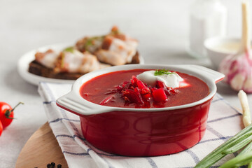 Delicious fresh red borscht, dark bread with lard and salt n kitchen table. 