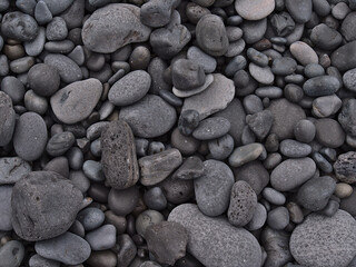 Fototapeta na wymiar Close-up high angle view of grey colored smooth volcanic pebble stones at Djúpalónssandur beach on the western coast of Snæfellsnes peninsula, Iceland.