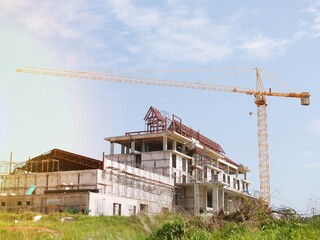 Obraz premium The building under construction overlooking the sky and clouds.
