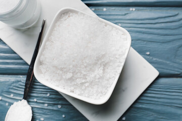 Bowl with salt on wooden background