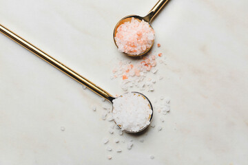 Spoons with different salt on white background