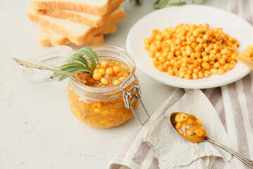 Jar of healthy sea buckthorn jam on table