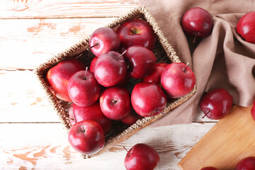 Basket with fresh red apples on table