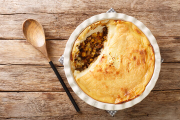 Canadian Pate Chinois pie with ground beef, corn and mashed potatoes close-up in a baking dish on the table. Horizontal top view from above