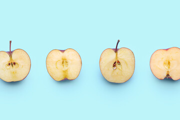 Pieces of fresh red apples on color background