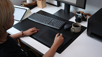 Cropped shot of graphic designer working with graphic tablet at modern office.