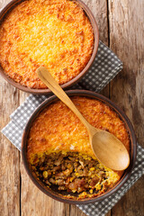 Pastel de Choclo Chilean Beef and Corn Casserole closeup in the bowl on the table. Vertical top view from above