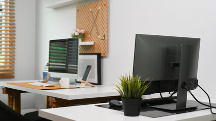 Modern home office interior with computers and office supplies.