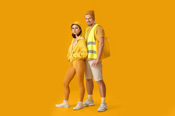 Stylish young couple on yellow background