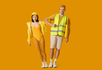 Stylish young couple on yellow background