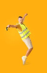 Fototapeta na wymiar Stylish male worker with headphones on yellow background