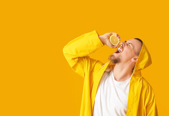 Stylish young man with lemon on yellow background