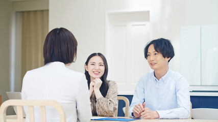 Fototapeta premium カップルと面談する女性 セールスウーマン ライフプランナー