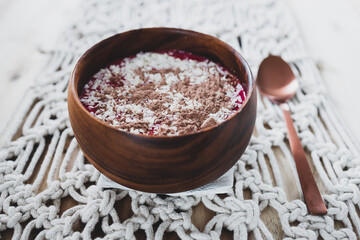 vegan smoothie bowl with raspberry vanilla oat milk smoothie topped with cocoa and coconut flakes, healthy plant-based food