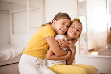 Kids at home. Sisters in hug.