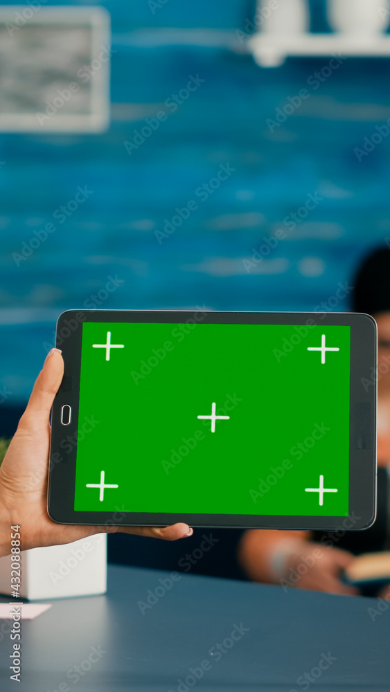Poster back view of woman holding tablet computer with mock up green screen chroma key display. caucasian f