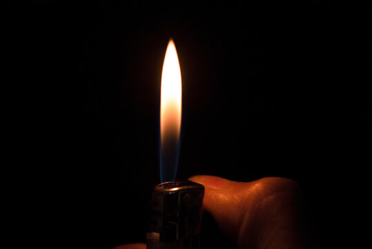 fire lighter with hand on a black background
