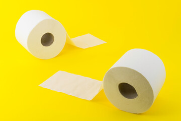 View of two rolls of toilet paper on yellow background