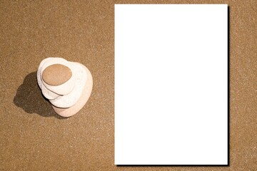 white blank paper sheet with shadow mockup balanced stone pyramid on sand beach
