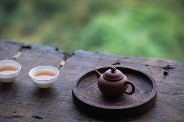 still life with tea. Two cups of tea and a teapot on the old wooden board table. Tea table by the window.