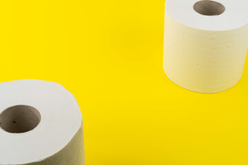 View of two rolls of toilet paper on yellow background