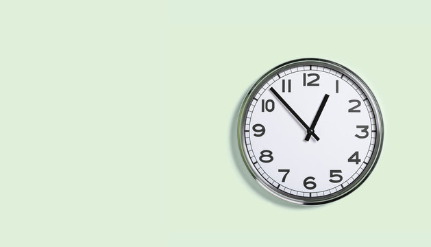 Plain wall clock on pastel green background. One o'clock. Close up banner with copy space, time management or business concept and lunch time. Opening or closing hours. Schedule or working hours